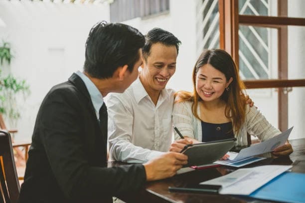 Khách hàng vui vẻ trao đổi hợp đồng cùng chuyên viên tư vấn